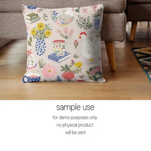 May include: A square cushion featuring a beige backdrop adorned with a vibrant floral design. The pattern showcases illustrations of flowers, a hen, books, and teacups. The cushion is made of fabric.