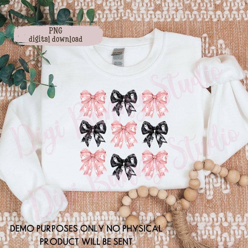 May include: A white sweatshirt with a design of nine pink and black bows with ghost patterns. The bows are arranged in three rows of three. The text "PNG digital download" is in the top left corner of the image.