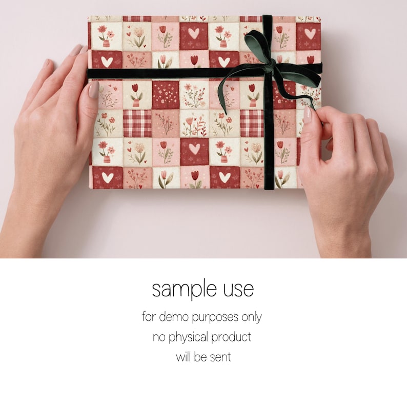 Peut inclure: Un coffret rectangulaire envelopp&eacute; dans du papier &agrave; motifs avec un motif floral et en forme de c&oelig;ur dans des tons de rouge, rose et cr&egrave;me. La bo&icirc;te est attach&eacute;e avec un ruban noir et un n&oelig;ud en velours vert. Le texte "sample use" est visible.