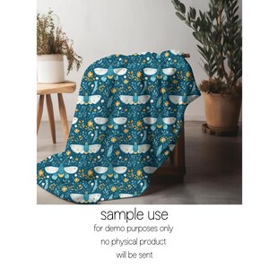 May include: A teal blue throw blanket with a repeating pattern of white butterflies and yellow flowers.