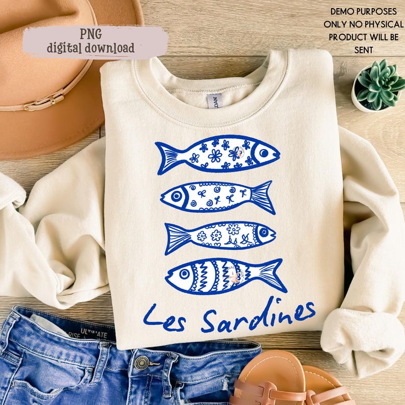 May include: Cream-colored sweatshirt featuring four blue fish designs with floral and patterned details. The text "Les Sardines" is written in blue script below the fish. The words "PNG digital download" are in a light pink box.