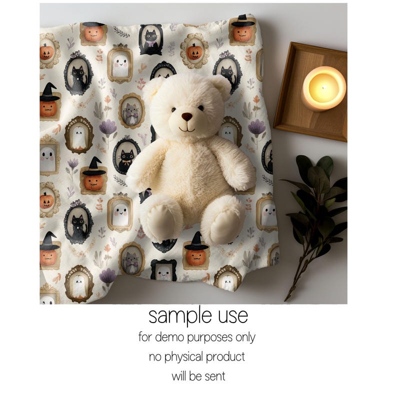 May include: A cream-colored teddy bear sits on a Halloween-themed fabric. The fabric features framed illustrations of pumpkins, ghosts, and black cats. The text "sample use for demo purposes only no physical product will be sent" is visible.