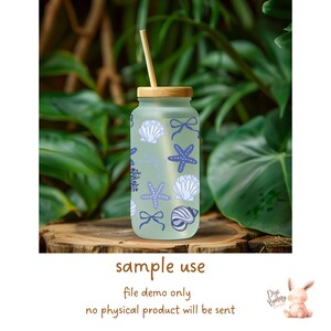 May include: A frosted glass water bottle with a bamboo lid and straw. The bottle has a blue and white design with seashells and starfish.