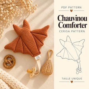 Può includere: Un doudou in tessuto a forma di pipistrello color ruggine con clip per ciuccio, un massaggiagengive a forma di pretzel marrone e un sonaglio in vimini. Il testo riporta PDF PATTERN, Chauvinou Comforter, CERISA PATTERN e TAILLE UNIQUE.