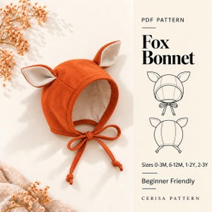 May include: A rust-orange bonnet with two pointed ears featuring cream-colored inner linings and matching tie strings. The text reads PDF PATTERN Fox Bonnet, Sizes 0-3M, 6-12M, 1-2Y, 2-3Y, Beginner Friendly, and CERISA PATTERN with line drawings.