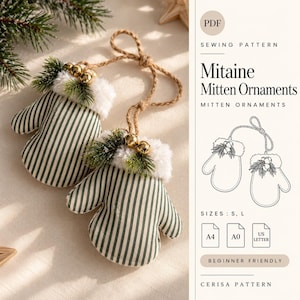 May include: Two fabric mitten ornaments featuring a dark green and white vertical stripe pattern, white faux fur cuffs, small green pine sprigs, and gold jingle bells. A jute twine loop is attached to each for hanging. The text reads Mitaine Mitten Ornaments.