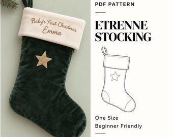Op de afbeelding: Een donkergroene kerstkous van fluweel met een crèmekleurige boord geborduurd met de tekst Baby's First Christmas Emma en een gouden ster. Inclusief een PDF-patroon voor de Etrenne-kous van Cerisa Pattern.