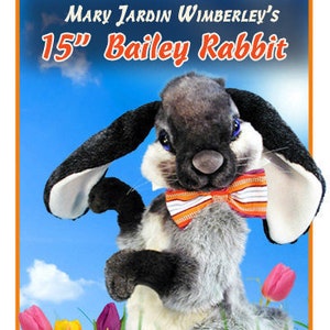 Può includere: Un modello per un giocattolo di peluche Bailey Rabbit da 15 pollici. Il modello presenta un coniglio grigio e nero con un papillon colorato, in piedi in un campo di fiori. Il modello è intitolato "Mary Jardin Wimberley's 15" Bailey Rabbit Pattern".