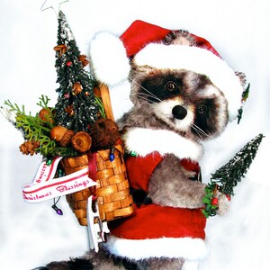 May include: A raccoon wearing a Santa hat and carrying a basket of Christmas decorations. The basket is decorated with a red and white ribbon that says "Christmas Blessings".