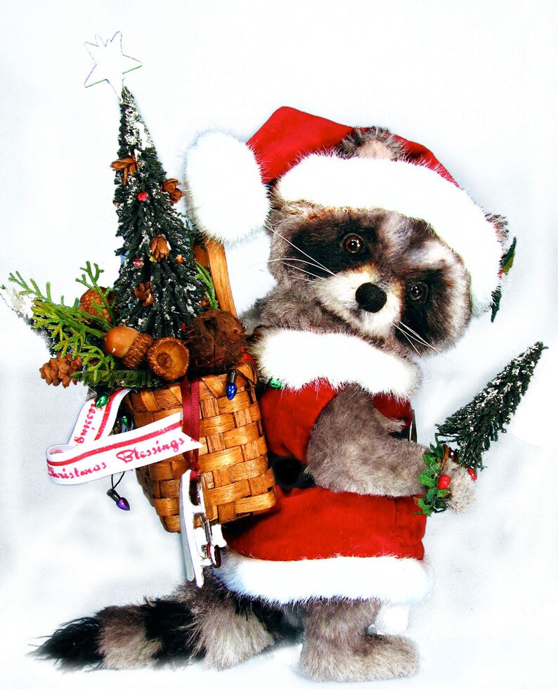 May include: A raccoon wearing a Santa hat and carrying a basket of Christmas decorations. The basket is decorated with a red and white ribbon that says "Christmas Blessings".