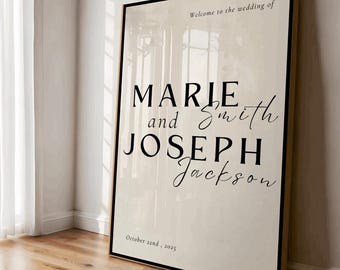 May include: A framed wedding sign with the names Marie and Joseph Jackson, and the date October 22nd, 2025. The sign has a cream-colored background with black text and a black frame. The words "Welcome to the wedding of" are at the top.