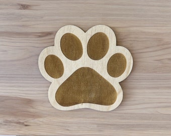 May include: A wooden paw print cutout with a brown center. The paw print is a decorative element for a home.