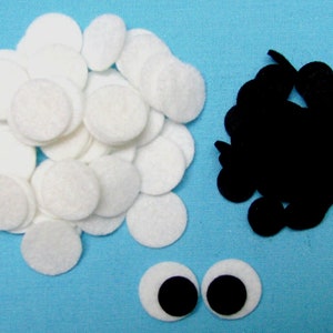 May include: A pile of white felt circles, a pile of black felt circles, and two white felt circles with black felt centres. These felt circles are great for crafting projects.