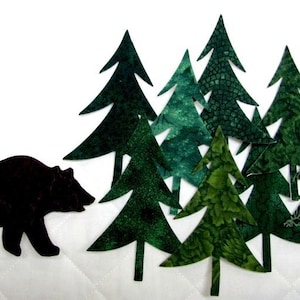 May include: A black bear silhouette stands to the left of a group of green felt Christmas trees. The trees are various shades of green and have different patterns.