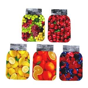 May include: Five flat, jar-shaped decorative cutouts featuring vibrant fruit prints. The designs include green and red grapes, bright red cherries, yellow lemons, orange slices, and a mix of blue and red berries, all topped with a black lid graphic.