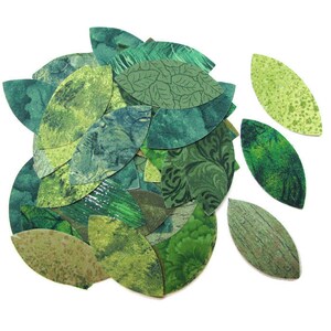 May include: A collection of green fabric leaves, some with patterns, some with a solid green colour. The leaves are cut out in a teardrop shape.