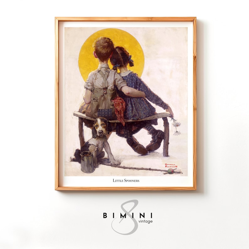 May include: A framed print of a vintage illustration titled "Little Spooners." The artwork depicts two children sitting on a bench with a dog, set against a yellow sun. The frame is a light brown color.