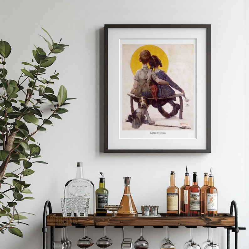 May include: Framed print of a vintage illustration depicting two children sitting on a bench with a dog. The artwork features a yellow sun in the background and is titled "Little Spooners". The frame is black.