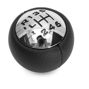 Könnte beinhalten: Schwarzer Leder-Schalthebelknauf mit einer verchromten Oberseite. Die Oberseite hat ein 5-Gang-Schaltmuster mit den Zahlen 1, 2, 3, 4, 5 und R.