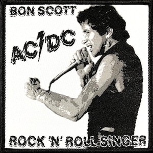 Könnte beinhalten: Schwarz-weiß gestickter Patch mit einem Porträt von Bon Scott, dem Leadsänger von AC/DC, der in ein Mikrofon singt. Der Text "Bon Scott AC/DC Rock 'n' Roll Singer" ist ebenfalls auf dem Patch enthalten.