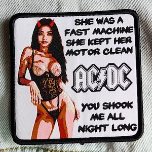 May include: A white patch with black trim features a woman with red horns and a black corset. The text reads "She was a fast machine, she kept her motor clean, AC/DC, You shook me all night long."