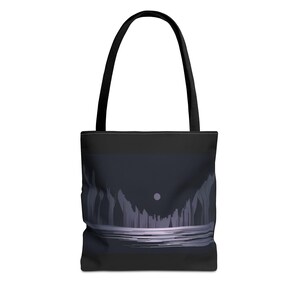 May include: A black tote bag with a graphic of a dark blue landscape with a white moon and a light blue waterline.
