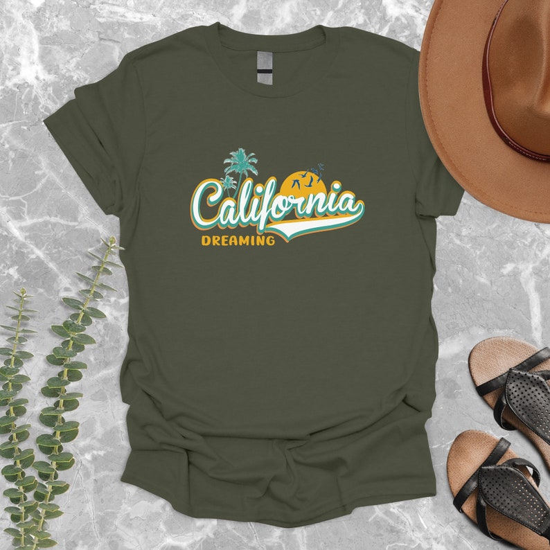May include: A green t-shirt with a retro-style graphic of palm trees, a sunset, and the text "California Dreaming".