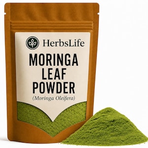 May include: A brown stand-up pouch containing green moringa leaf powder. The white label features the text HerbsLife, MORINGA LEAF POWDER, and (Moringa Oleifera) with a circular logo. A small pile of the fine green powder sits in front of the pouch.
