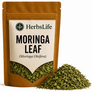May include: A brown stand-up pouch containing dried green moringa leaves. The label features the text HerbsLife, MORINGA LEAF, and Moringa Oleifera. A pile of the loose, dried green leaves sits in front of the pouch on a plain white background.
