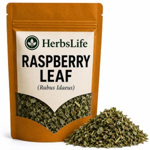 May include: A brown stand-up pouch with a clear window containing dried green raspberry leaves. The label features the text HerbsLife, RASPBERRY LEAF, and (Rubus Idaeus) in black ink. A small pile of the dried green leaves sits in front of the pouch.