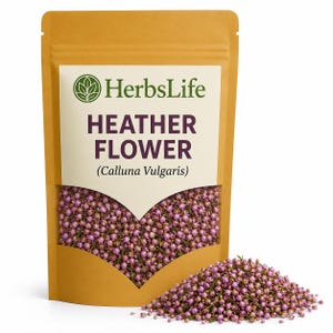 May include: A tan packet of Heather Flower (Calluna Vulgaris) from HerbsLife. The packet has a heart-shaped window showing small, dried, pinkish-purple flowers. A small pile of the same flowers is in front of the packet.