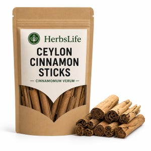 May include: A brown kraft paper pouch labelled HerbsLife Ceylon Cinnamon Sticks Cinnamomum Verum with a clear window showing cinnamon sticks inside. A small pile of light brown, rolled cinnamon bark sticks sits to the right of the pouch.