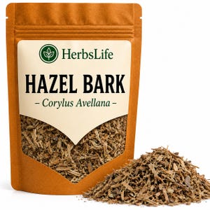 May include: A brown stand-up pouch containing dried hazel bark, labelled HerbsLife Hazel Bark Corylus Avellana. The front features a clear window displaying the brown, shredded bark pieces, with a pile of the same bark resting in front of the pouch.