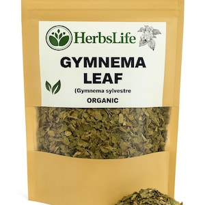 Puede incluir: Una bolsa de color beige de hoja de Gymnema orgánica, con la marca "HerbsLife" y el texto "GYMNEMA LEAF" en negrita. La bolsa es parcialmente transparente, revelando hojas verdes secas. Un pequeño montón de hojas se encuentra en la parte inferior.