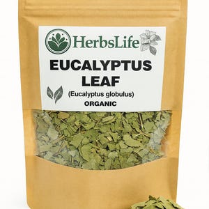 Puede incluir: Una taza de cerámica blanca con un asa negra y el texto "But First, Coffee" en negrita negra. La taza se encuentra sobre un fondo borroso, sugiriendo un ambiente acogedor.