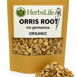Op de afbeelding: Een bruin gekleurde zak met biologische orriswortel, met een transparant venster dat de gedroogde wortelstukken laat zien. De zak heeft een wit label met de tekst "HerbsLife", "ORRIS ROOT", "iris germanica" en "ORGANIC". Een kleine hoop orriswortel ligt ervoor.