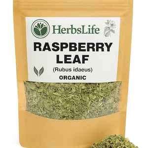 May include: A package of dried raspberry leaf, labeled "Raspberry Leaf (Rubus idaeus) ORGANIC" by HerbsLife. The package is a light brown color with a clear window showing the green leaves. A small pile of the leaves sits in front of the package.