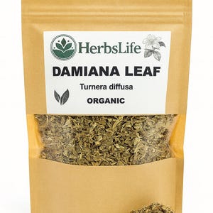 Puede incluir: Una bolsa de papel marrón con una ventana transparente, llena de hojas de damiana secas. La bolsa tiene una etiqueta blanca con el texto "HerbsLife DAMIANA LEAF Turnera diffusa ORGANIC" y un logotipo floral. Un pequeño montón de hierba seca está en la parte inferior.