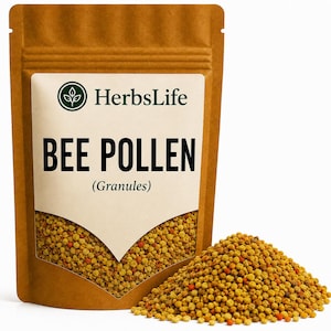 Pode incluir: Uma bolsa vertical castanha contendo grânulos de pólen de abelha com um rótulo que diz HerbsLife BEE POLLEN (Granules) e um logótipo circular com um ícone de planta. Um monte de pequenos grânulos amarelos e cor de laranja está à frente.