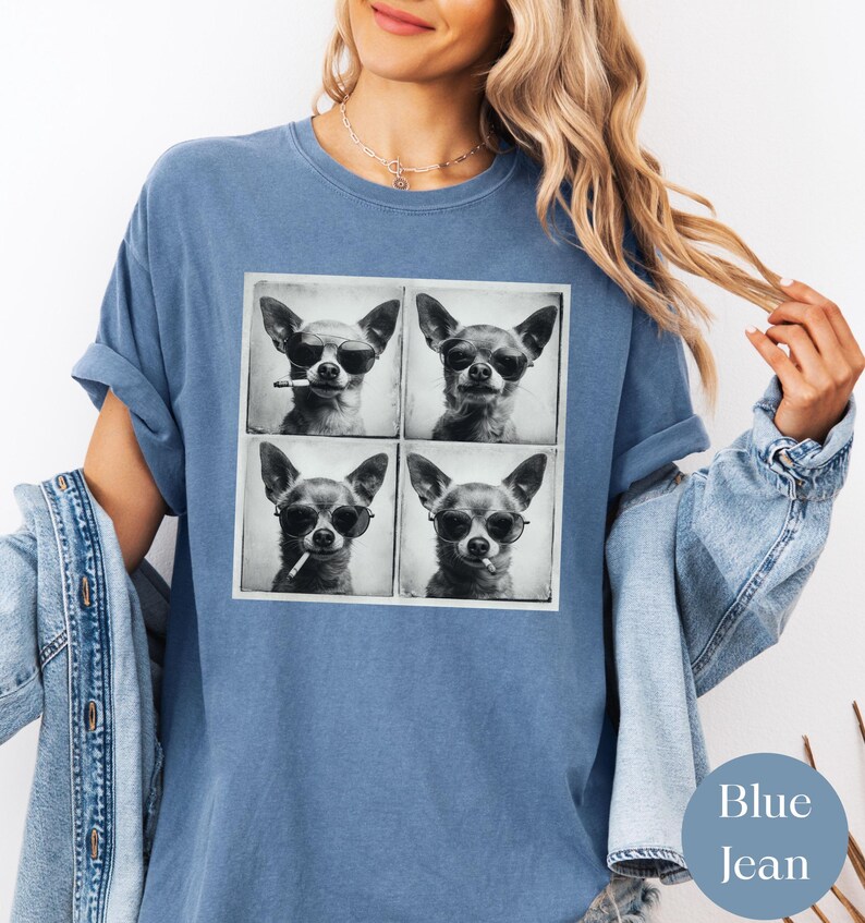 Pu&ograve; includere: T-shirt blu jeans con un'immagine a quattro pannelli di un chihuahua con occhiali da sole e una sigaretta. Il cane &egrave; in una foto in bianco e nero. La maglietta ha un girocollo e maniche corte.