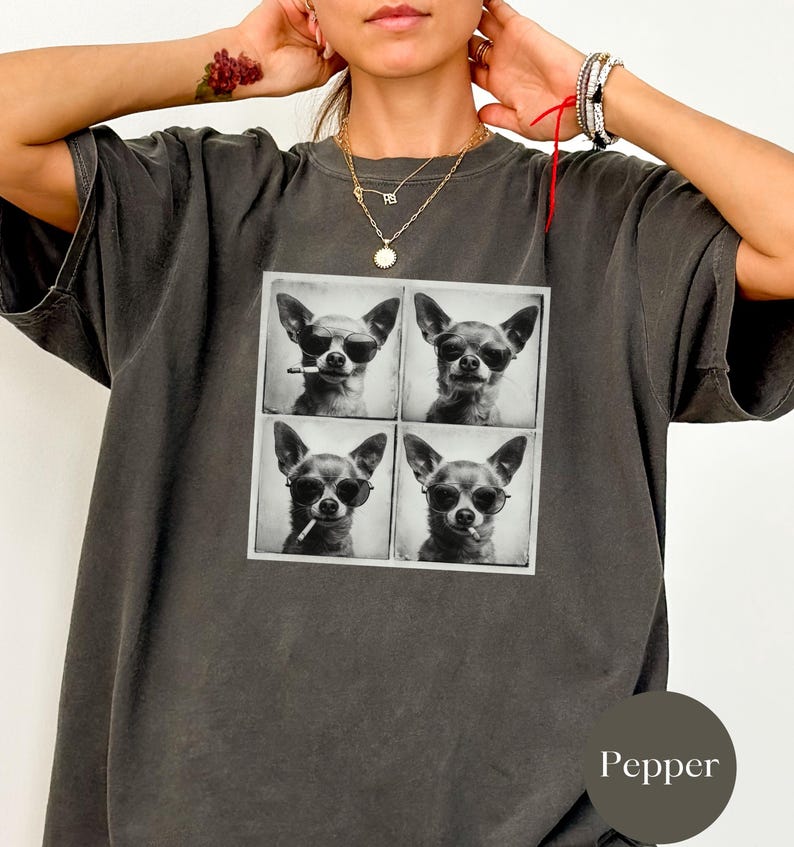 Pu&ograve; includere: T-shirt grigio scuro con una grafica quadrata di quattro immagini in bianco e nero di un Chihuahua con occhiali da sole, alcuni con sigarette. La maglietta ha una vestibilit&agrave; ampia.