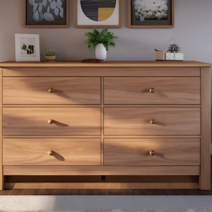 May include: A six-drawer dresser made of light wood with brass knobs. The dresser has a simple design and is a great addition to any bedroom.