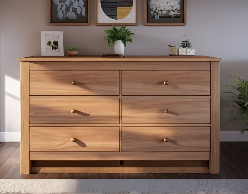 May include: A six-drawer dresser made of light wood with brass knobs. The dresser has a simple design and is a great addition to any bedroom.