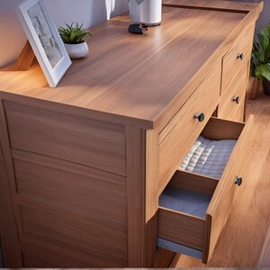 May include: A wooden dresser with six drawers, four of which are closed and two are open. The drawers have black metal handles. The dresser is made of light wood with a natural finish.