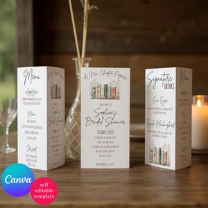 Può includere: Tre menu di carte piegate bianche per un addio al nubilato. I menu presentano testo e illustrazioni di libri e fiori. La carta centrale recita "Sophia's Bridal Shower" e "A New Chapter Begins".