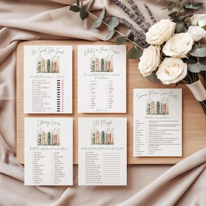 May include: A collection of five white cards with game prompts, featuring a watercolor illustration of books and flowers. The cards are arranged on a wooden board with a bouquet of white roses and greenery. The text on the cards includes "He Said, She Said" and "Literary Loves."