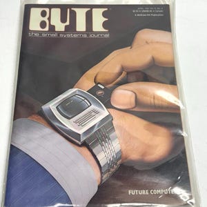 May include: A vintage BYTE magazine cover featuring a futuristic wristwatch computer. The magazine is in a plastic sleeve. The cover text reads "BYTE the small systems journal" and "FUTURE COMPUTER". The watch has a screen and keyboard.