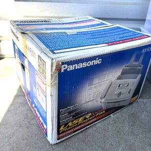 May include: A Panasonic KX-FL511 box, featuring a blue and white design. The box advertises a plain paper fax, copier, and telephone. The words "HIGH SPEED LASER FAX and COPIER" are also visible.