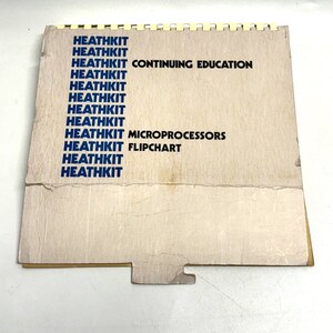 May include: A vintage Heathkit flipchart for continuing education in microprocessors. The cover is a light tan color with blue text that reads "HEATHKIT" multiple times, along with "CONTINUING EDUCATION", "MICROPROCESSORS", and "FLIPCHART". The pages are held together with a spiral binding.