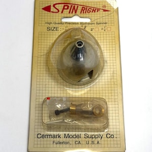 May include: A package containing a high-quality aluminum spinner for model aircraft. The package includes a clear plastic dome containing the spinner and a smaller compartment with additional hardware. The text "SPIN RIGHT" and "Cermark Model Supply Co." are visible.